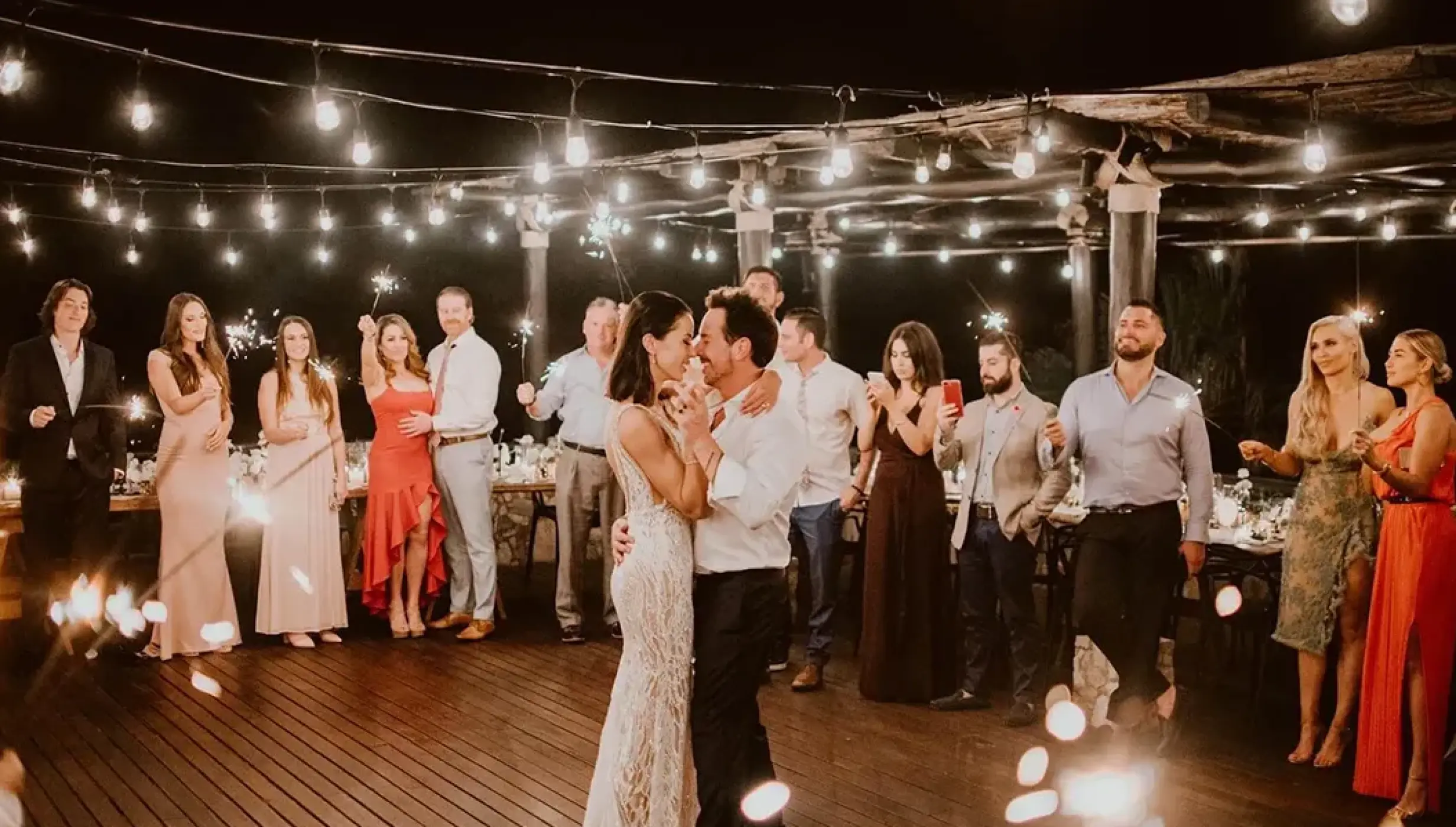 The couple dancing at a sparkler wedding reception under string lights at Esperanza, Cabo San Lucas