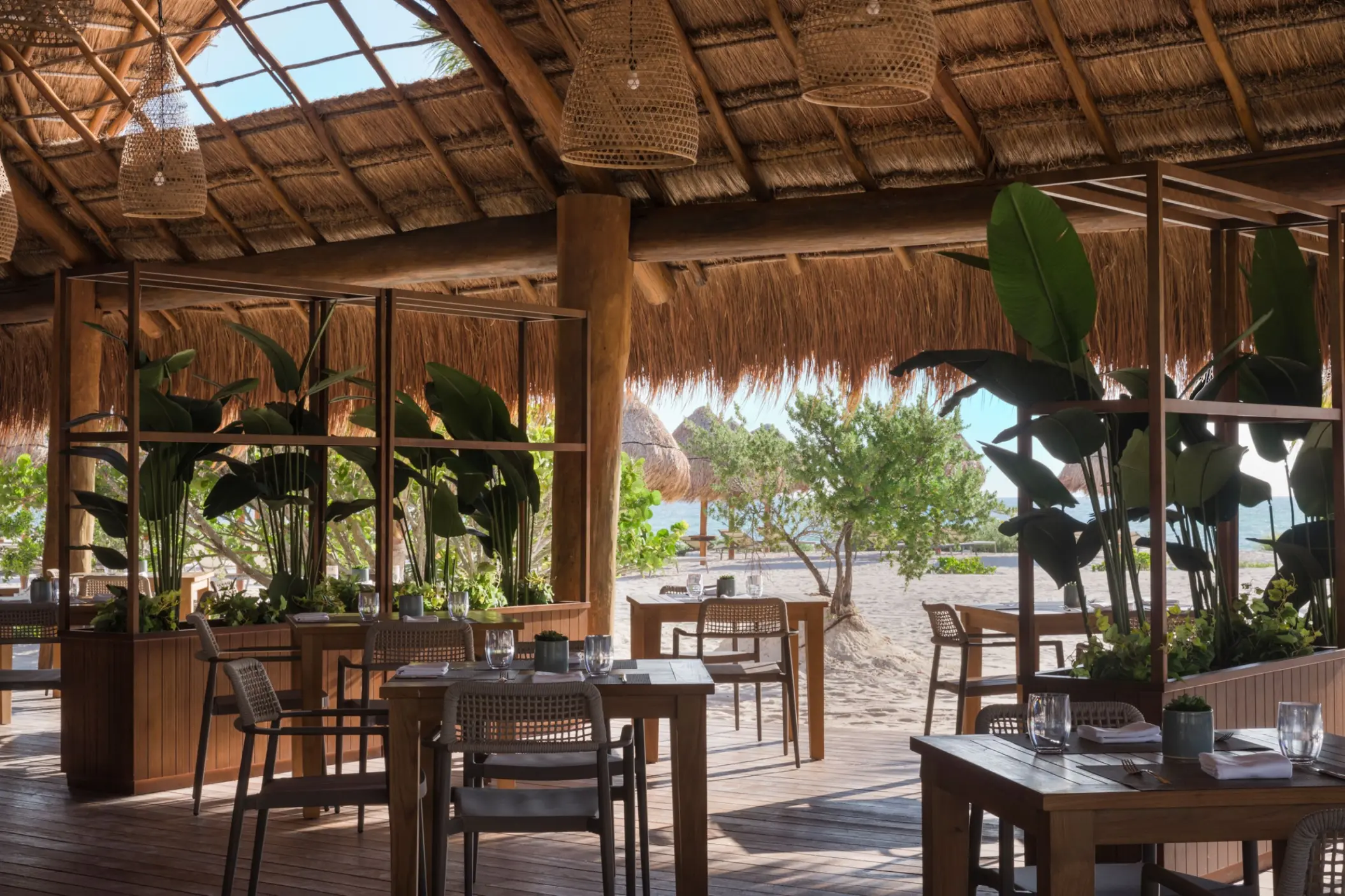 Las Olas restaurant with thatched roof and wooden tables at Excellence Coral Playa Mujeres, Cancun