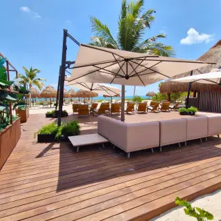 Las Olas terrace with lounge seating and umbrellas at Excellence Coral Playa Mujeres, Cancun