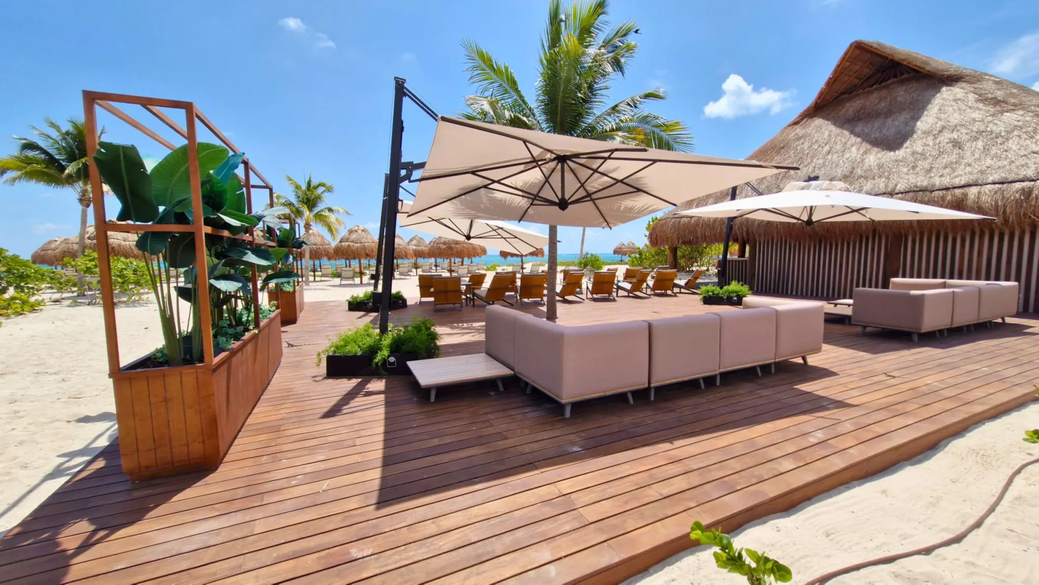 Las Olas terrace with lounge seating and umbrellas at Excellence Coral Playa Mujeres, Cancun