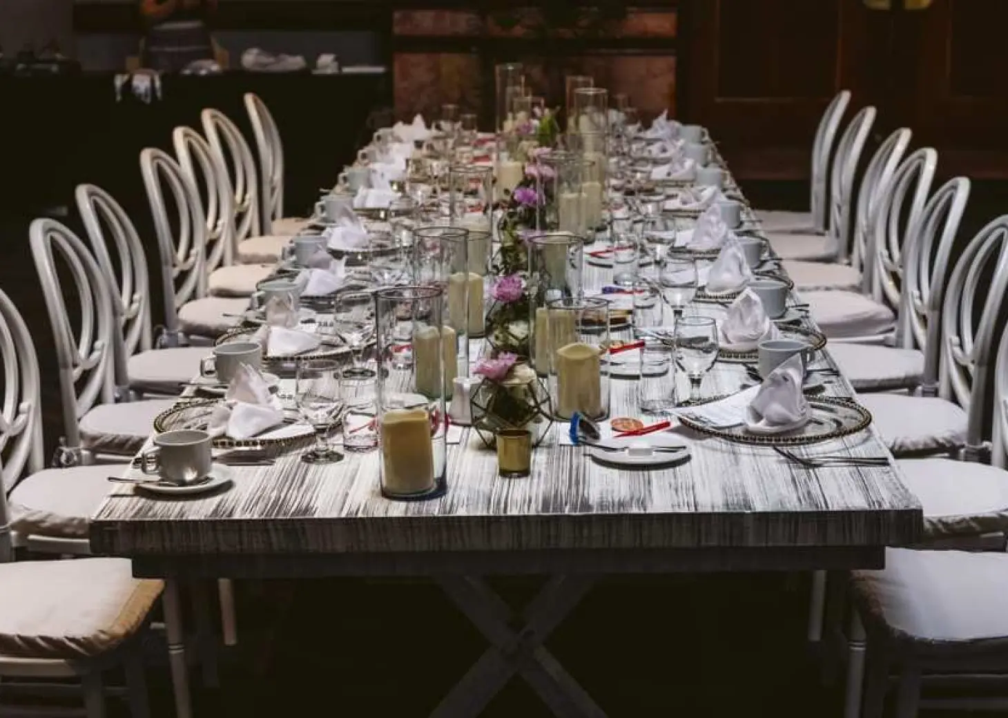 Long wooden banquet table with white chairs for a wedding reception at Fiesta Americana Condesa, Cancun