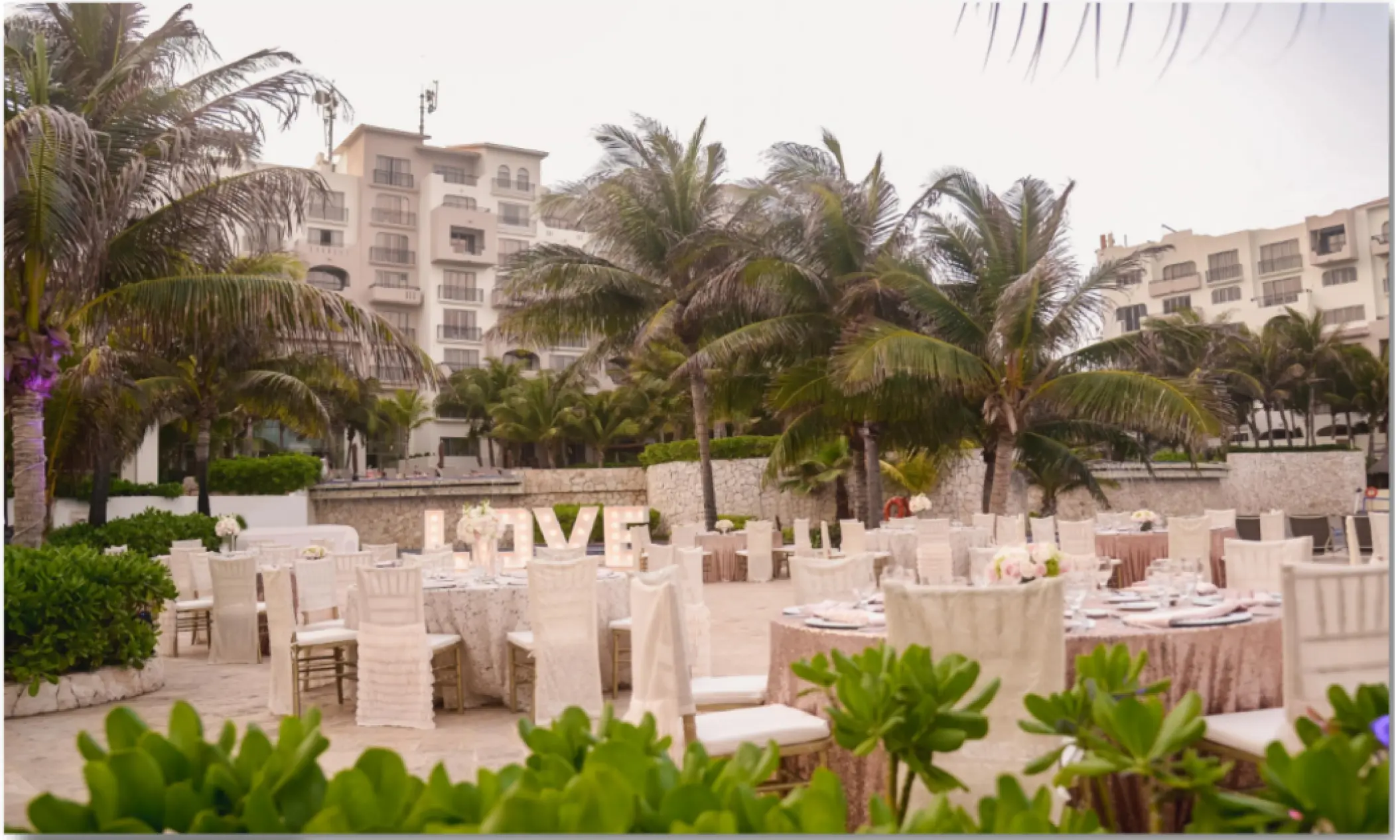 Outdoor wedding reception setup with light-up LOVE sign at Fiesta Americana Condesa, Cancun
