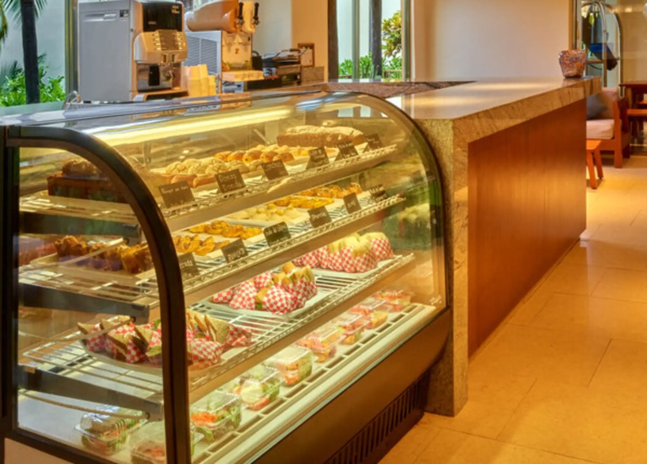 Deli counter with glass display case full of pastries and sandwiches at Fiesta Americana Condesa, Cancun