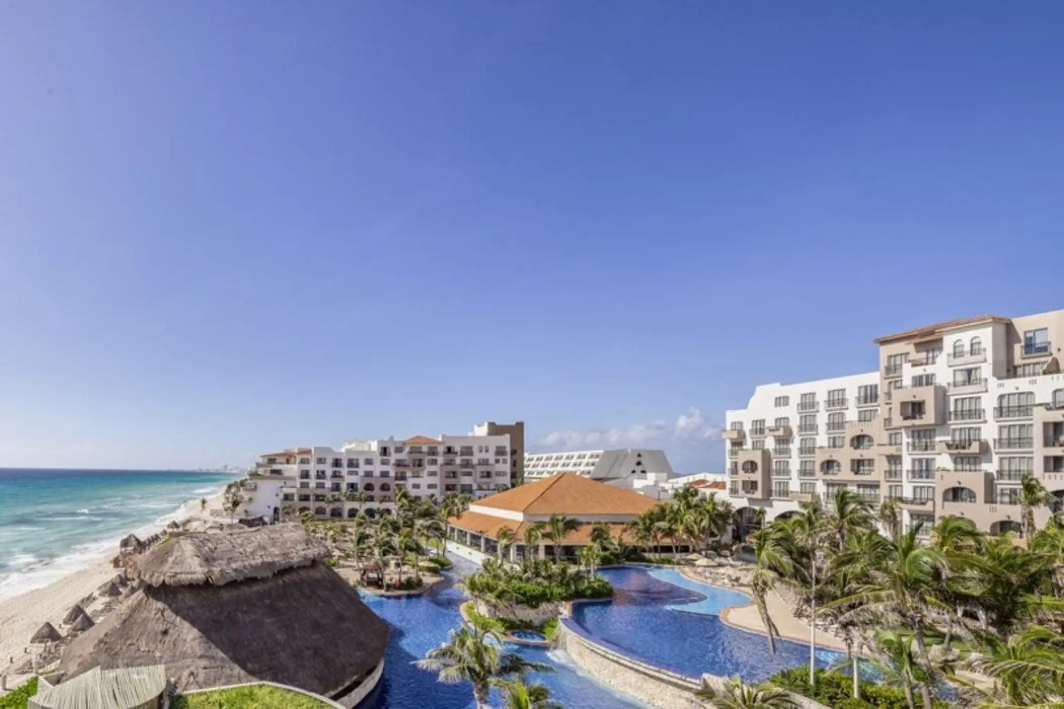 Side view of the multi-level pool and beachfront buildings at Fiesta Americana Condesa, Cancun