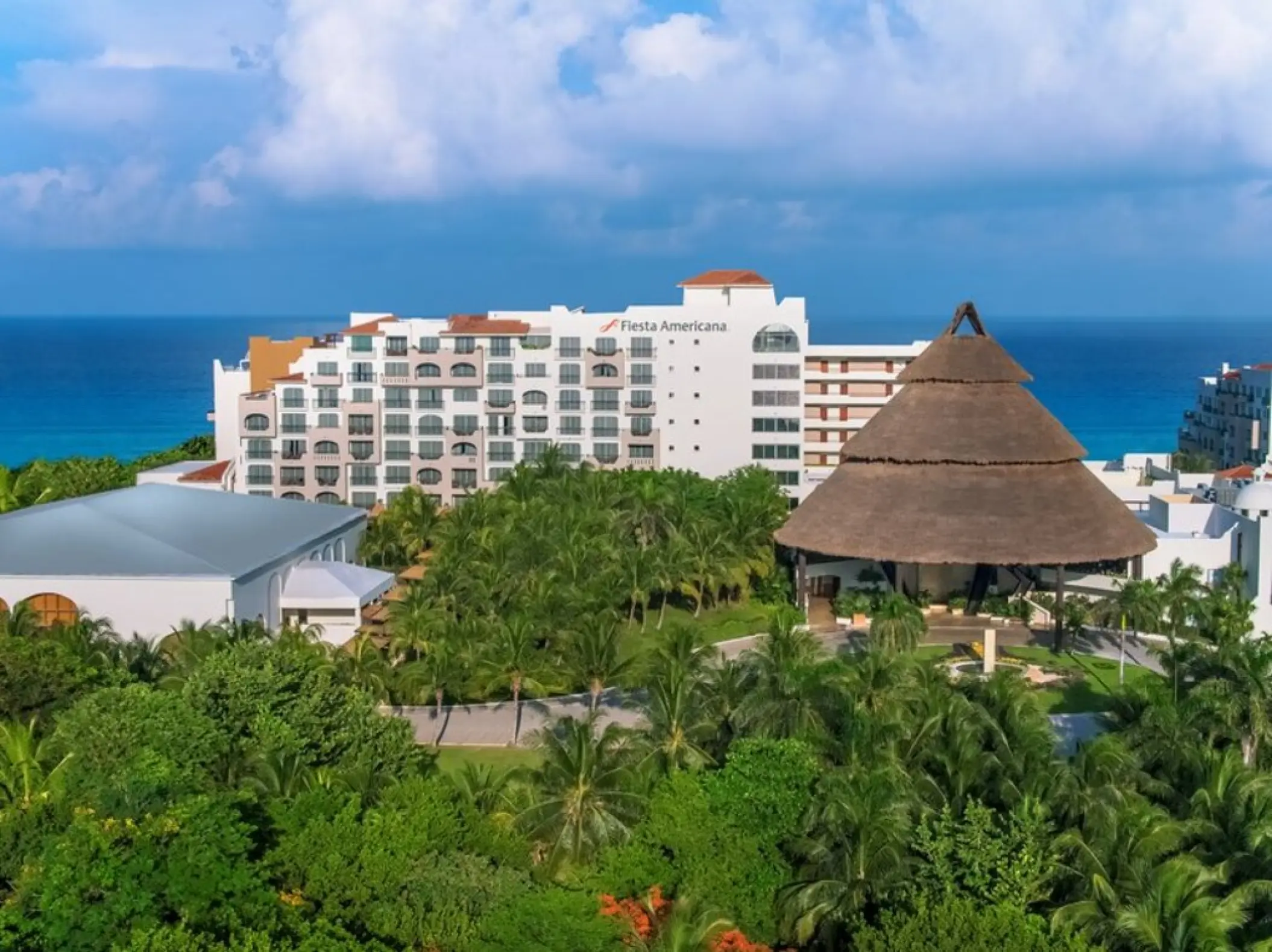 Fiesta Americana Condesa exterior and large palapa surrounded by palm trees, Cancun