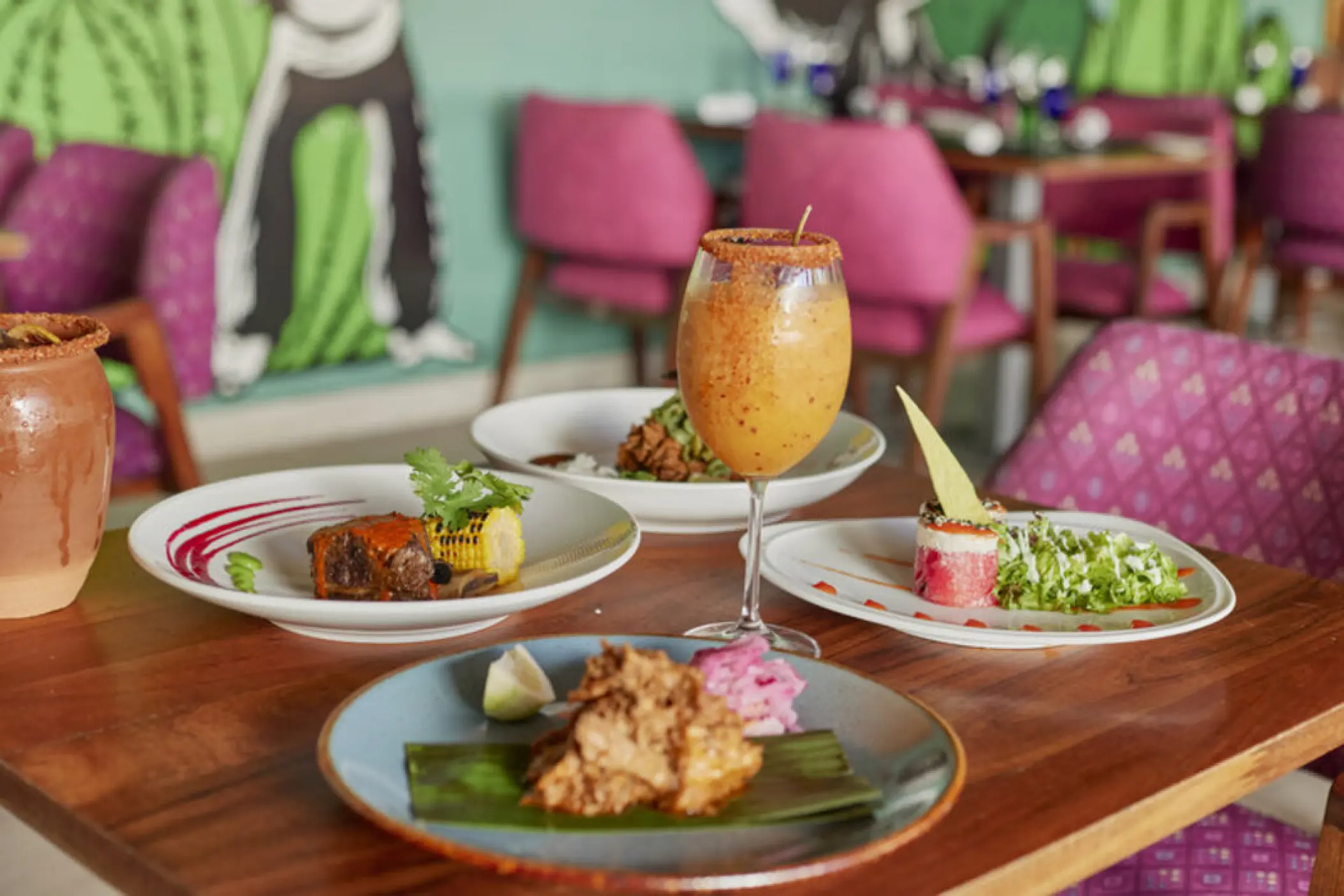Plated Mexican dishes and a specialty cocktail at El Mexicano restaurant in Fiesta Americana Condesa, Cancun