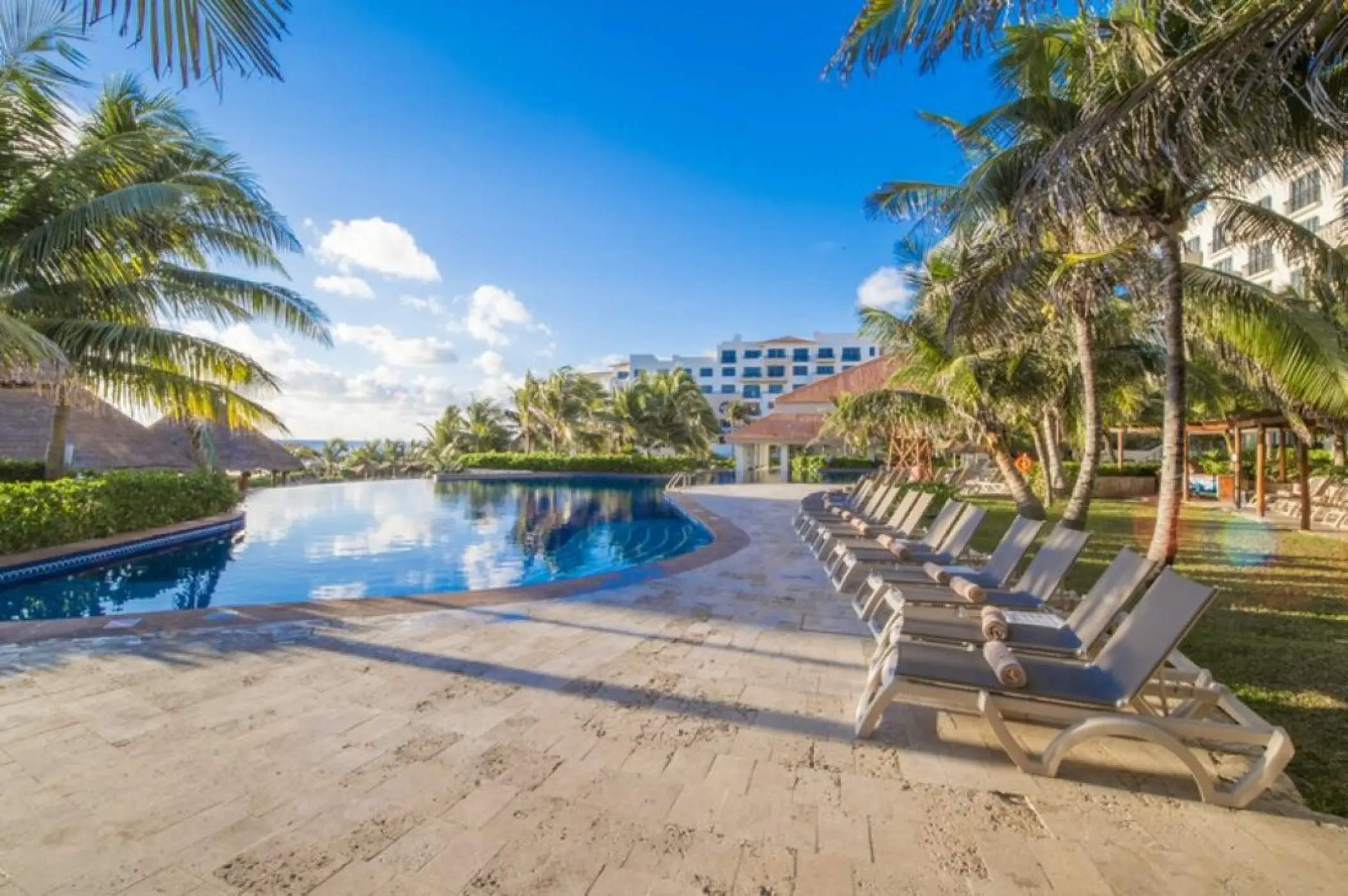 Fiesta Americana Condesa pool and sun loungers under palm trees, Cancun