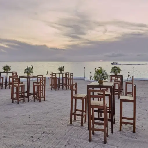 Beach club wedding reception setup with wooden high-top tables at Fiesta Americana Cozumel