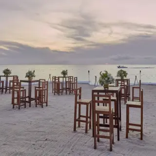 Beach club wedding reception setup with wooden high-top tables at Fiesta Americana Cozumel