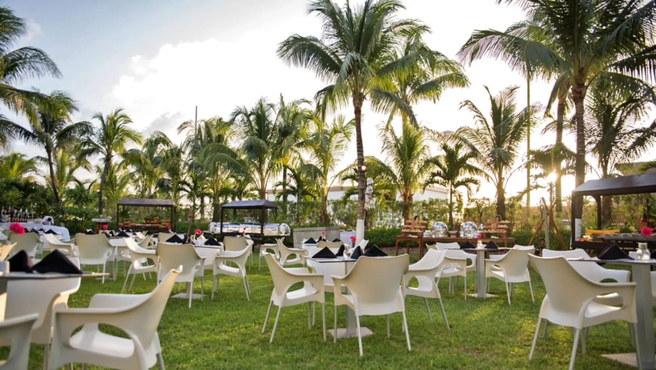 Garden wedding reception with white chairs and palm trees at Fiesta Americana Cozumel