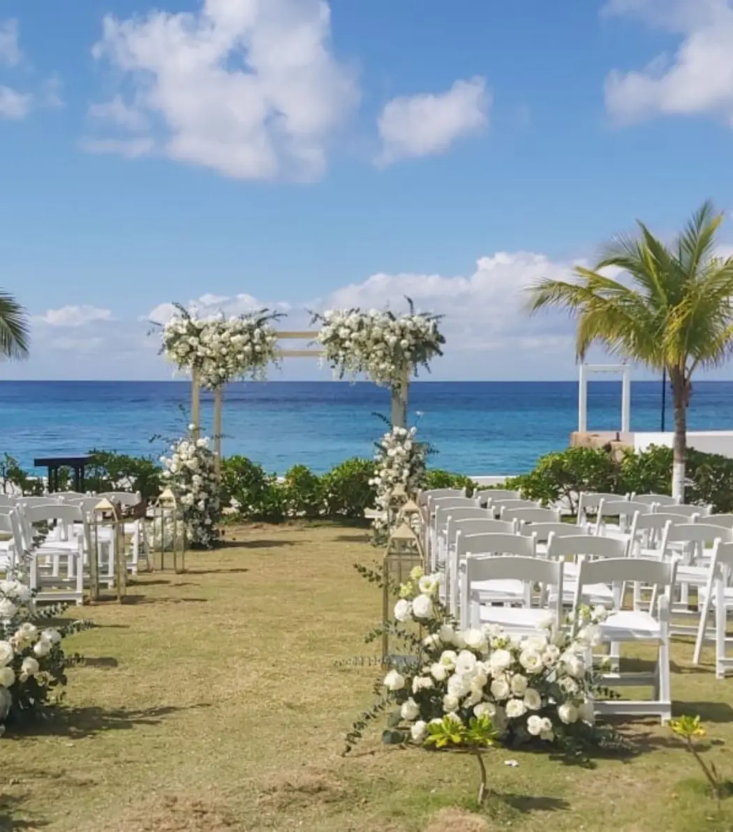 Garden wedding ceremony at Fiesta Americana Cozumel with white floral arch and ocean views