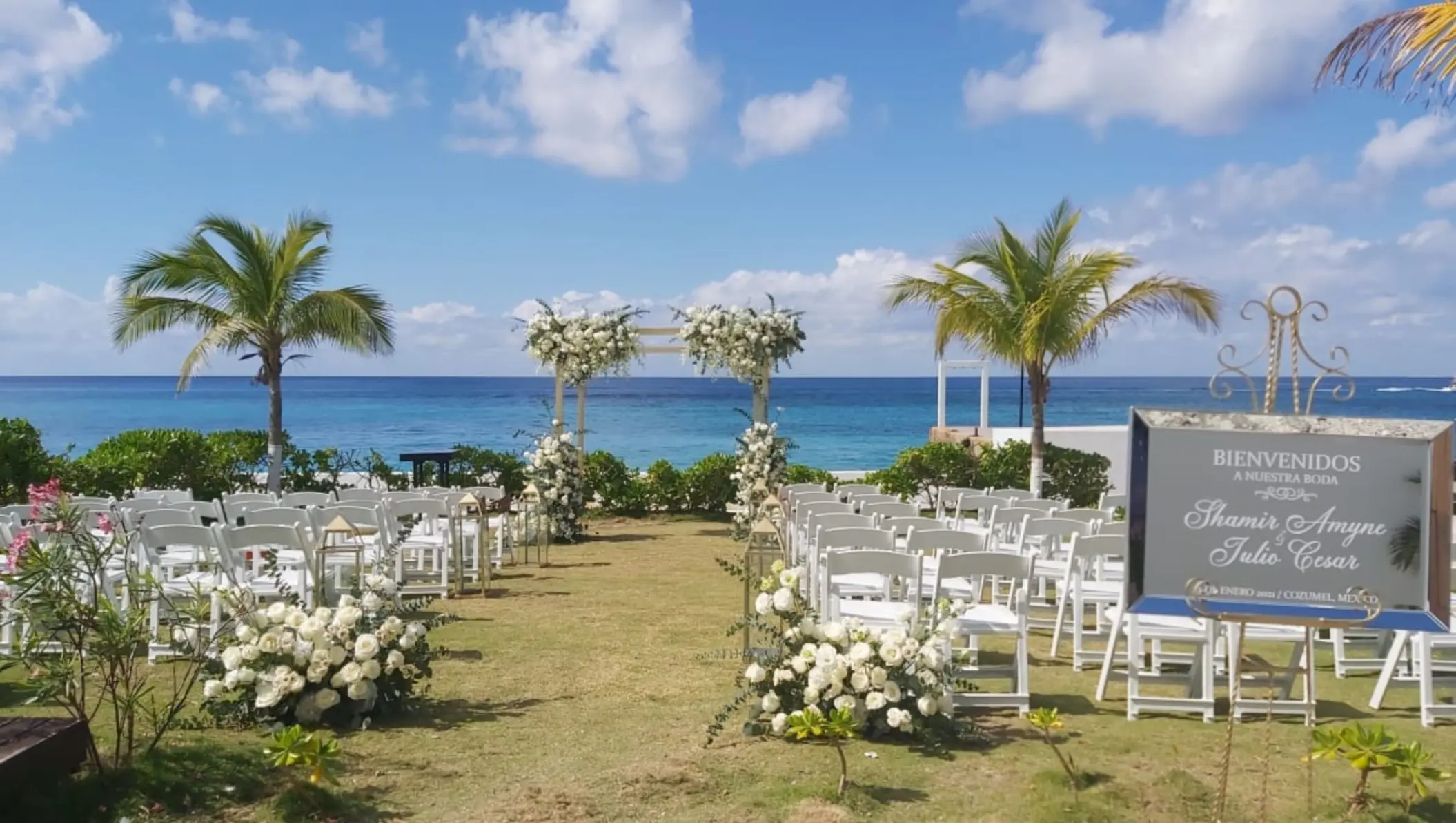 Garden wedding ceremony at Fiesta Americana Cozumel with white floral arch and ocean views