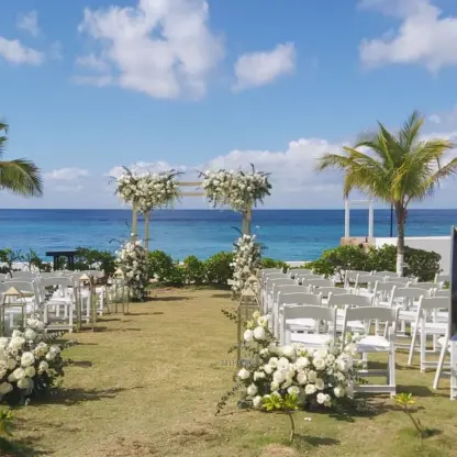 Garden wedding ceremony at Fiesta Americana Cozumel with white floral arch and ocean views