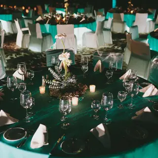 Indoor wedding reception setup with teal linens and candlelight at Fiesta Americana Puerto Vallarta