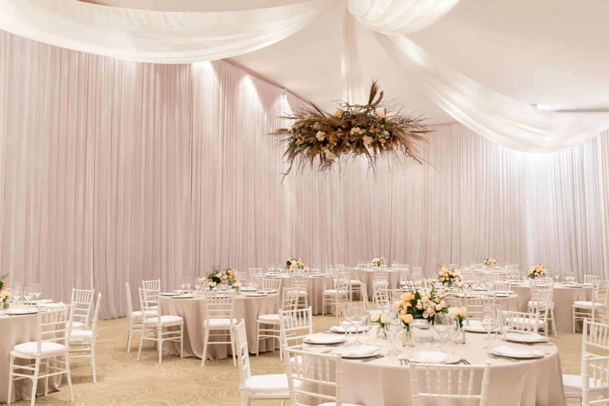 Indoor ballroom wedding reception with white draping and floral centerpieces at Finest Punta Cana, Punta Cana