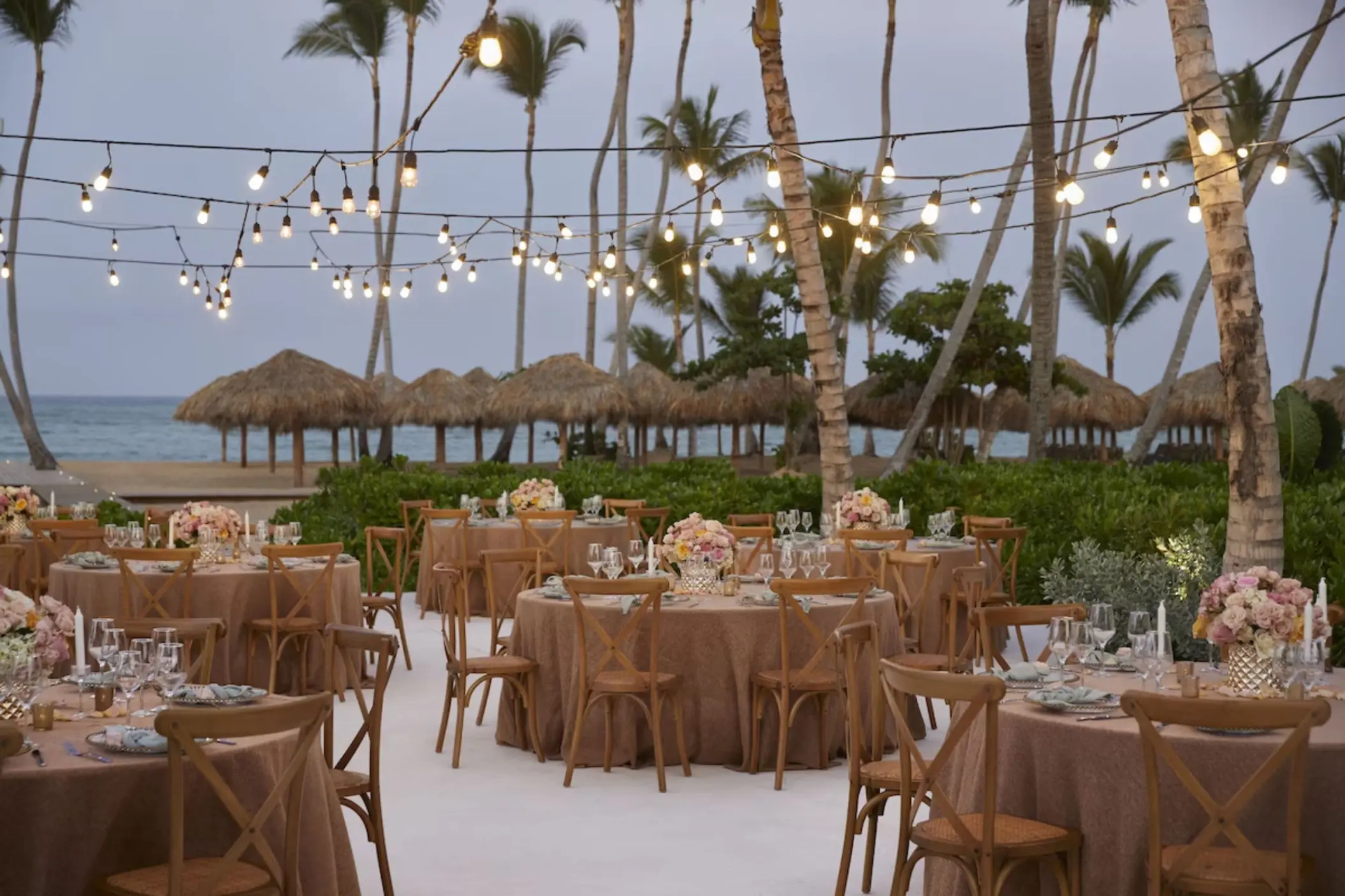 Outdoor wedding reception with string lights and round tables at Finest Punta Cana, Punta Cana