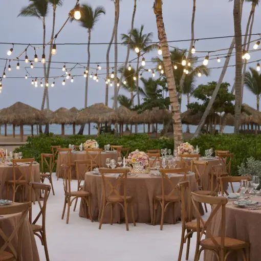Outdoor wedding reception with string lights and round tables at Finest Punta Cana, Punta Cana
