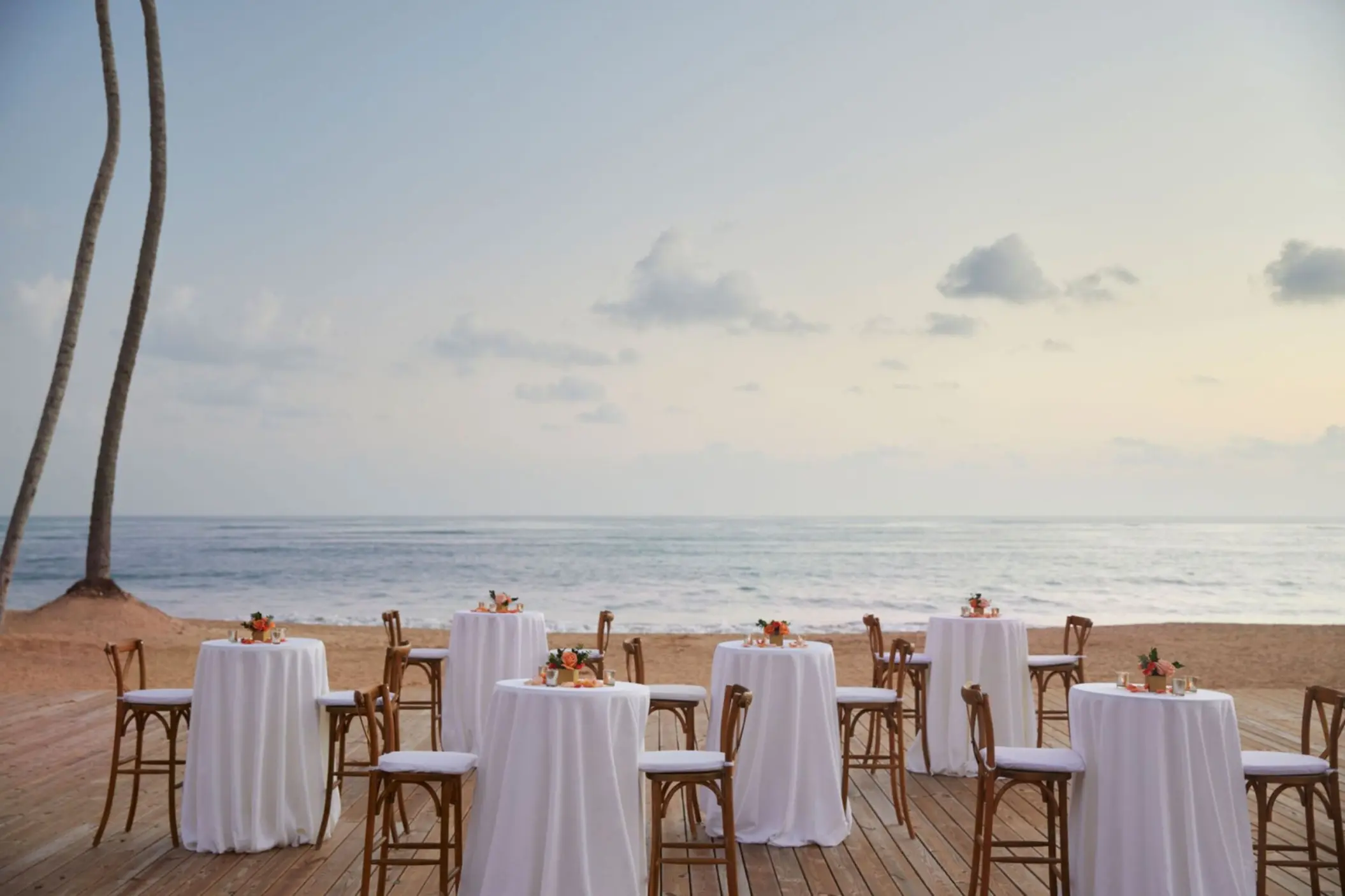 Beachfront wedding reception deck with cocktail tables at Finest Punta Cana