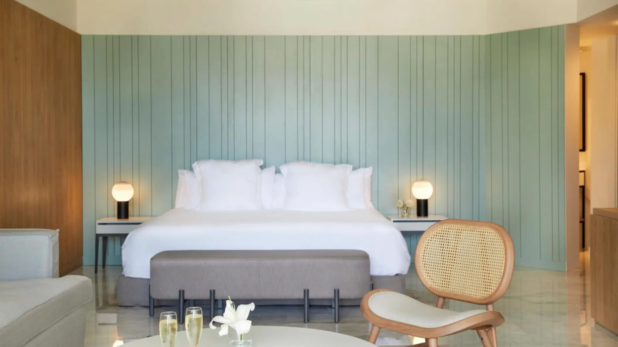 Excellence Club Junior Suite bedroom with sage green paneled wall at Finest Punta Cana, Punta Cana