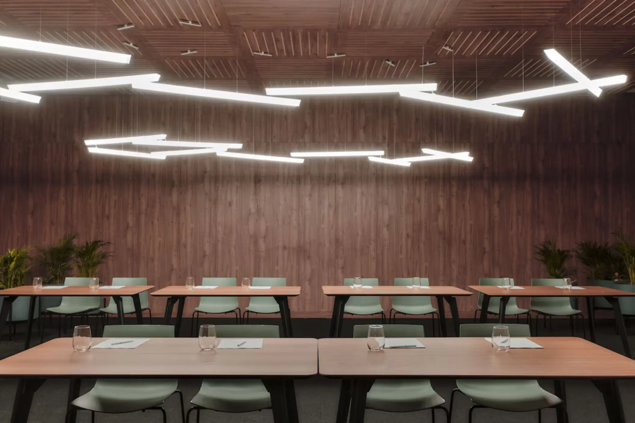 Modern meeting room with wood-paneled walls and geometric lighting at Finest Punta Cana, Punta Cana
