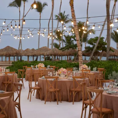 Terrace wedding reception with string lights and round tables at Finest Punta Cana, Punta Cana