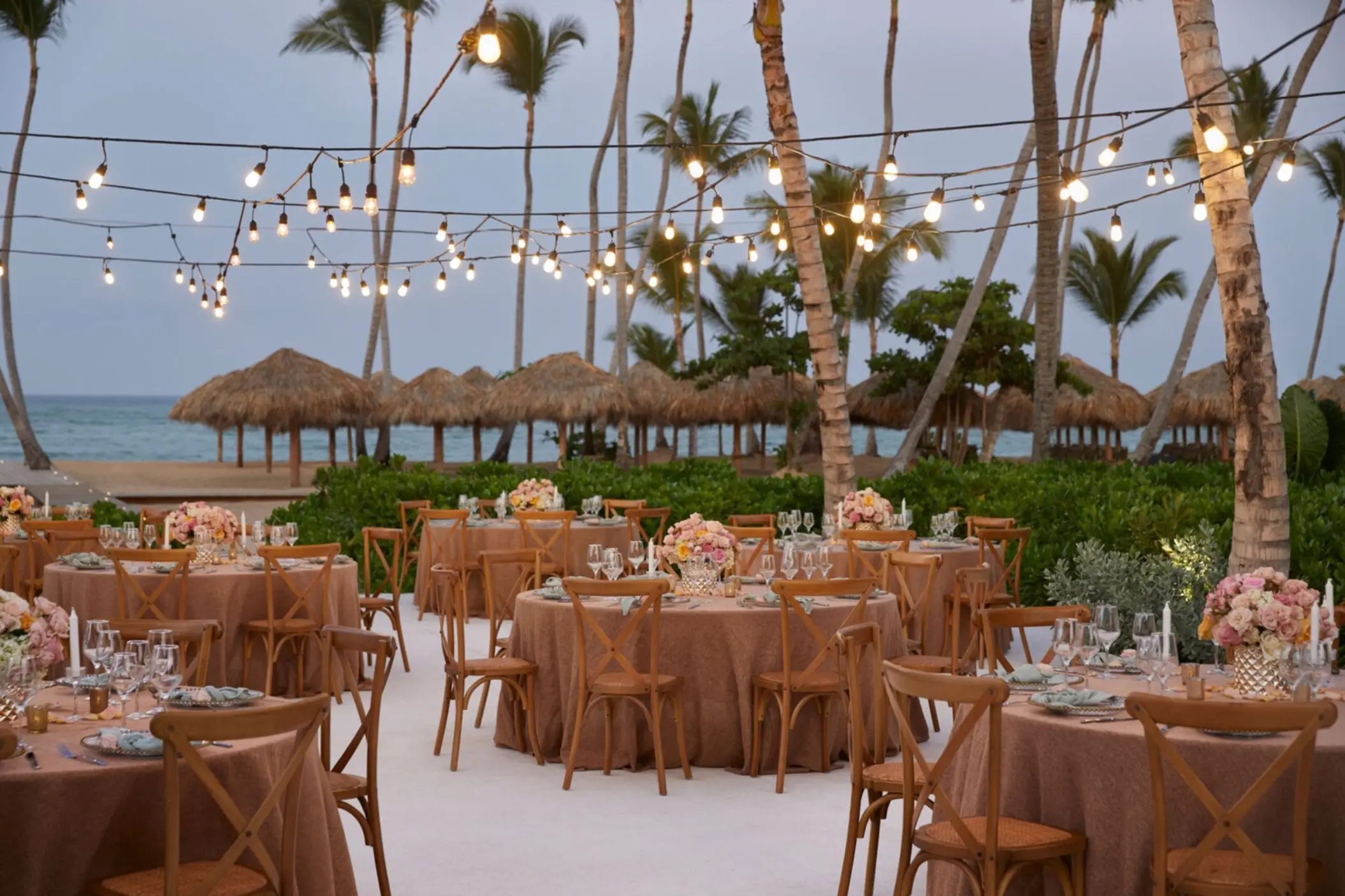 Terrace wedding reception with string lights and round tables at Finest Punta Cana, Punta Cana