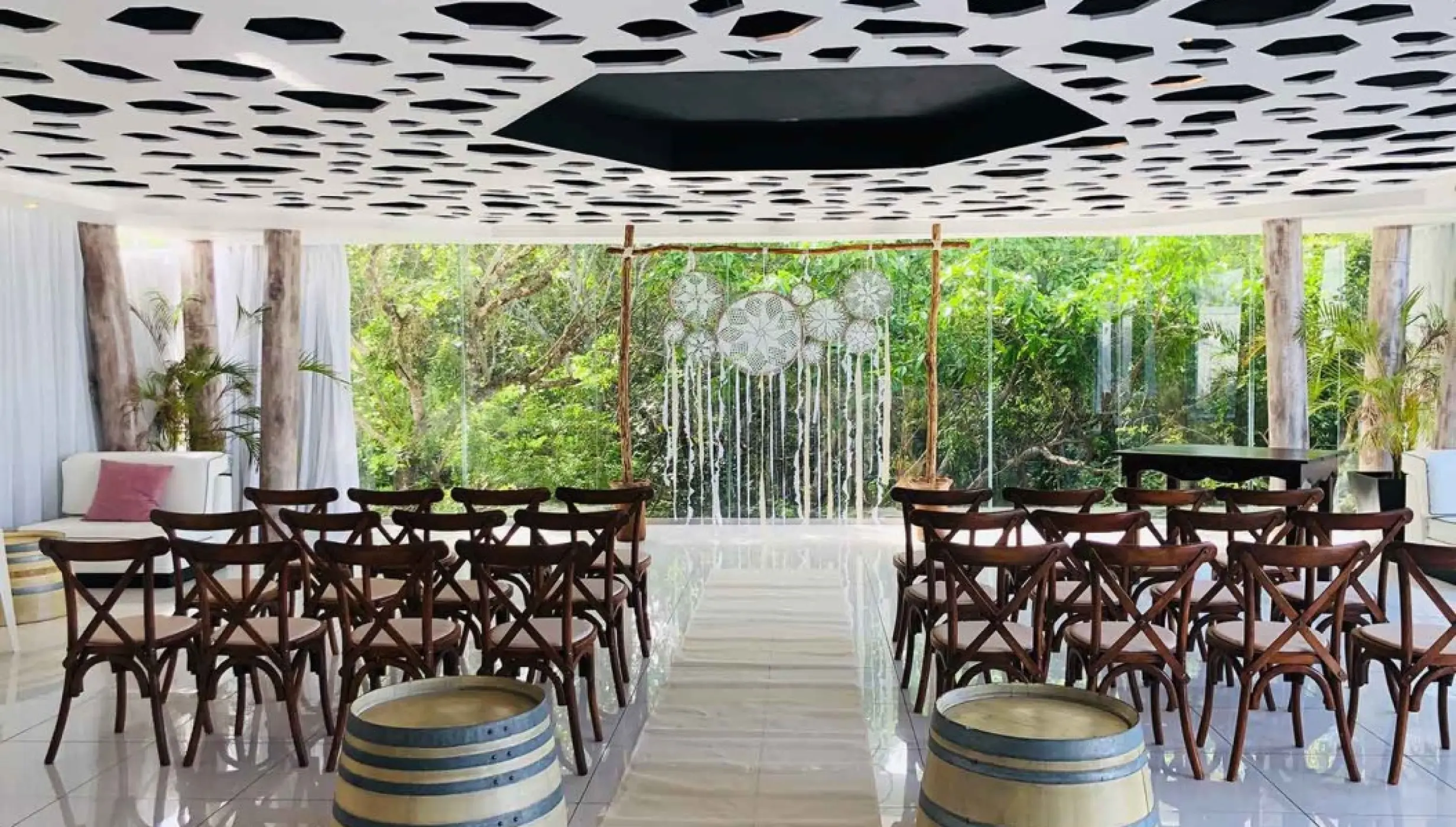 Indoor wedding ceremony at The Fives Beach, Playa Del Carmen with cross-back chairs and dreamcatcher backdrop