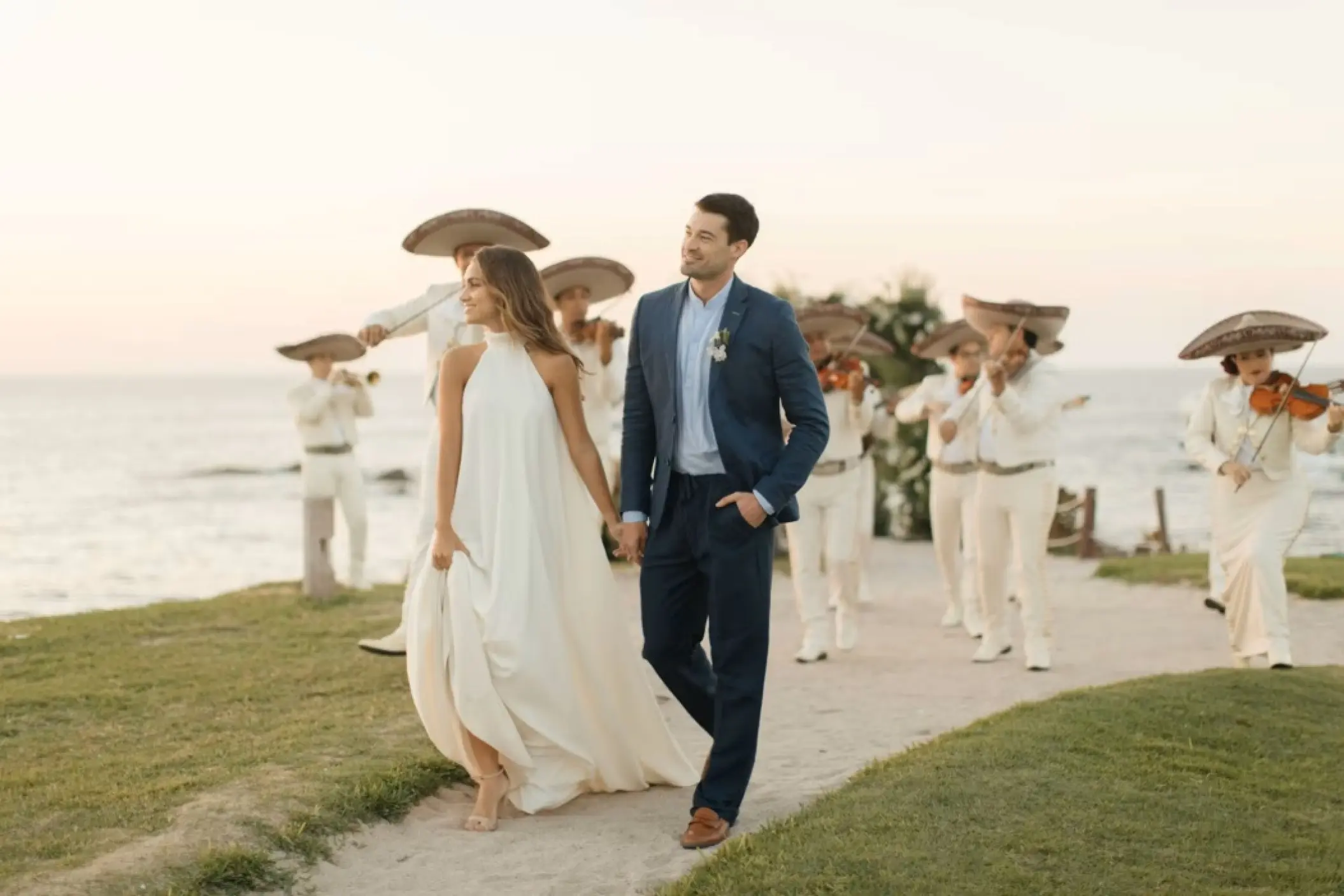 Bride and groom walking with a mariachi band at Four Seasons Punta Mita