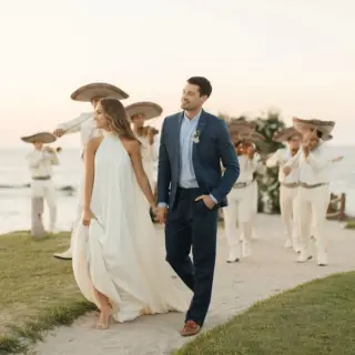 Bride and groom walking with a mariachi band at Four Seasons Punta Mita