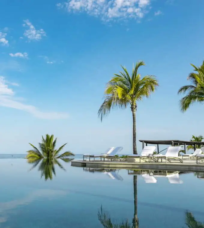 Four Seasons Punta Mita infinity pool and palm trees reflecting in the water, Punta Mita
