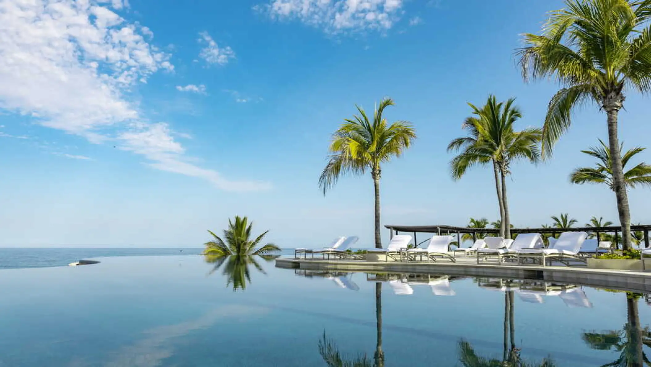Four Seasons Punta Mita infinity pool and palm trees reflecting in the water, Punta Mita