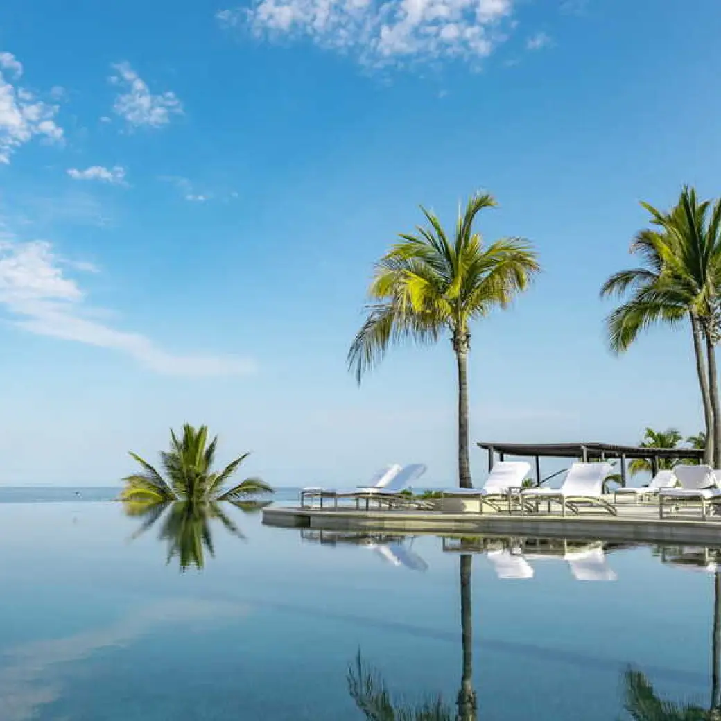 Four Seasons Punta Mita infinity pool and palm trees reflecting in the water, Punta Mita