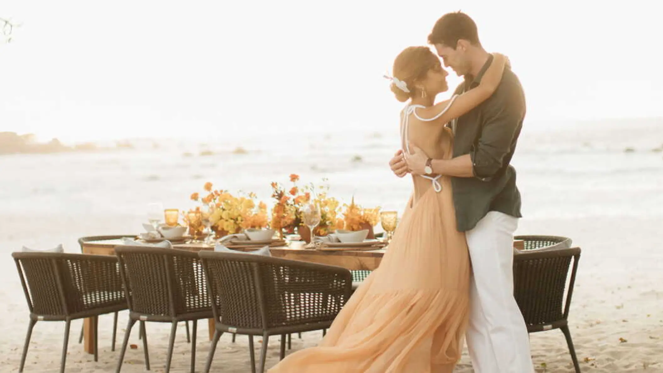 Couple embracing by a private beach dinner at Four Seasons Punta Mita
