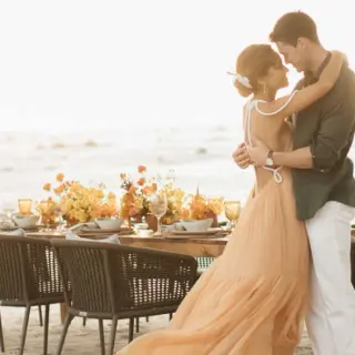 Couple embracing by a private beach dinner at Four Seasons Punta Mita