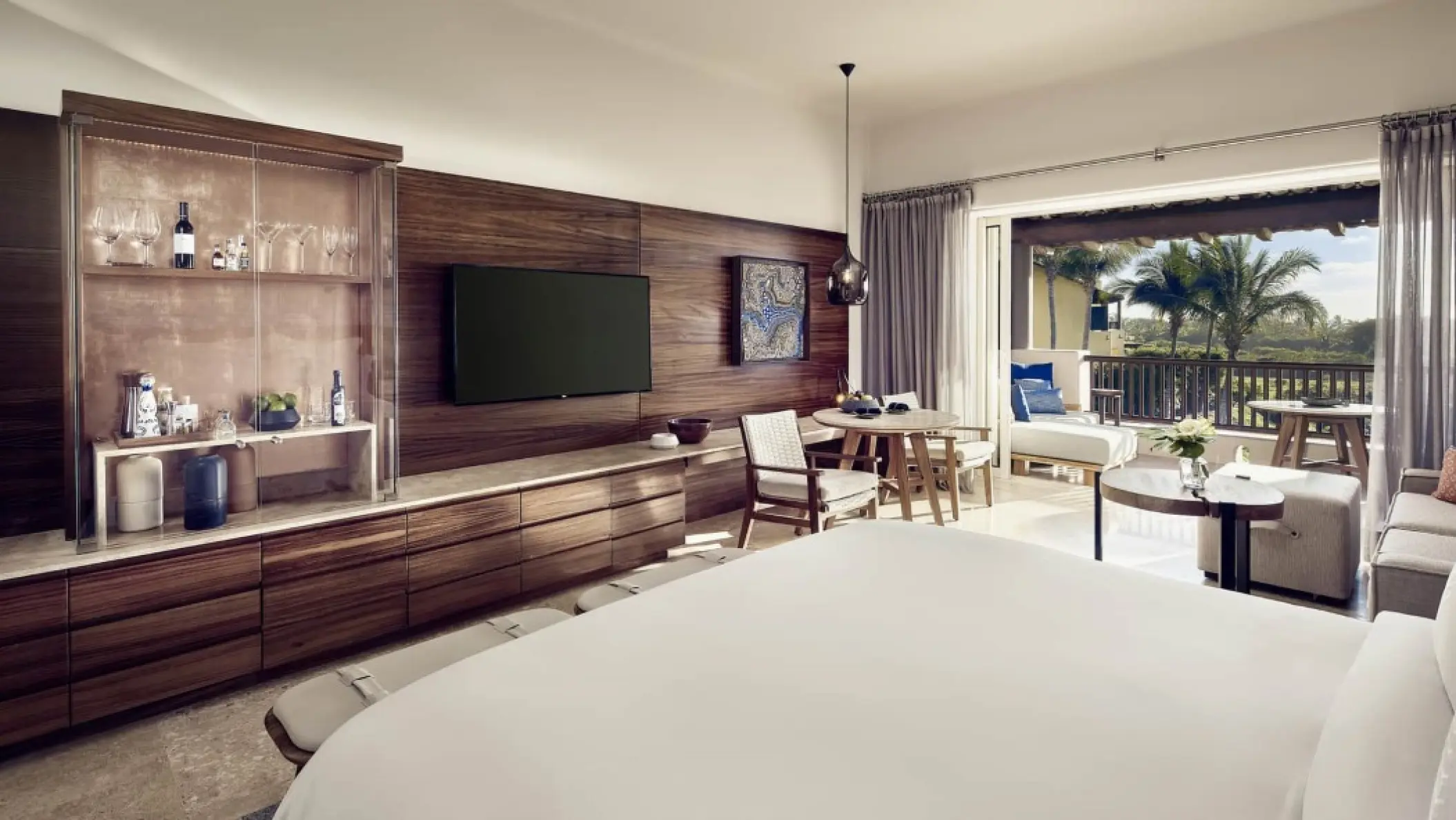 Modern suite with wood paneling and private balcony at Four Seasons Punta Mita