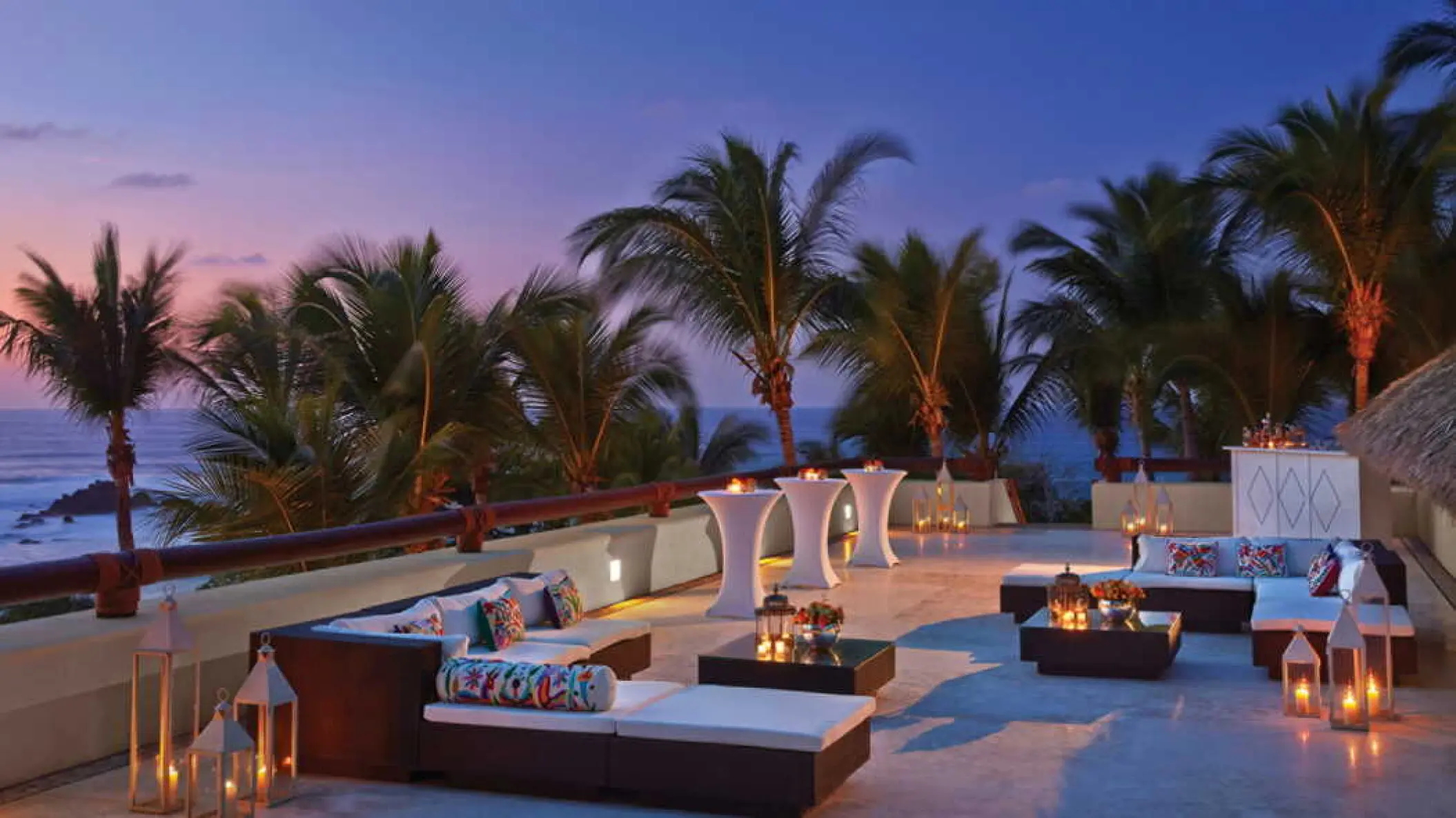 Outdoor wedding reception lounge with lanterns at Four Seasons Punta Mita at sunset