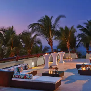 Outdoor wedding reception lounge with lanterns at Four Seasons Punta Mita at sunset