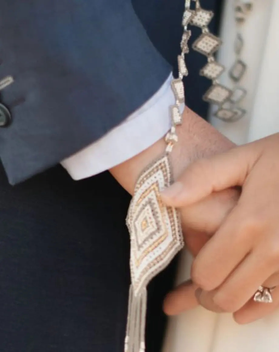 Close up of a couple holding hands with a traditional lasso for a wedding ceremony at Four Seasons Punta Mita