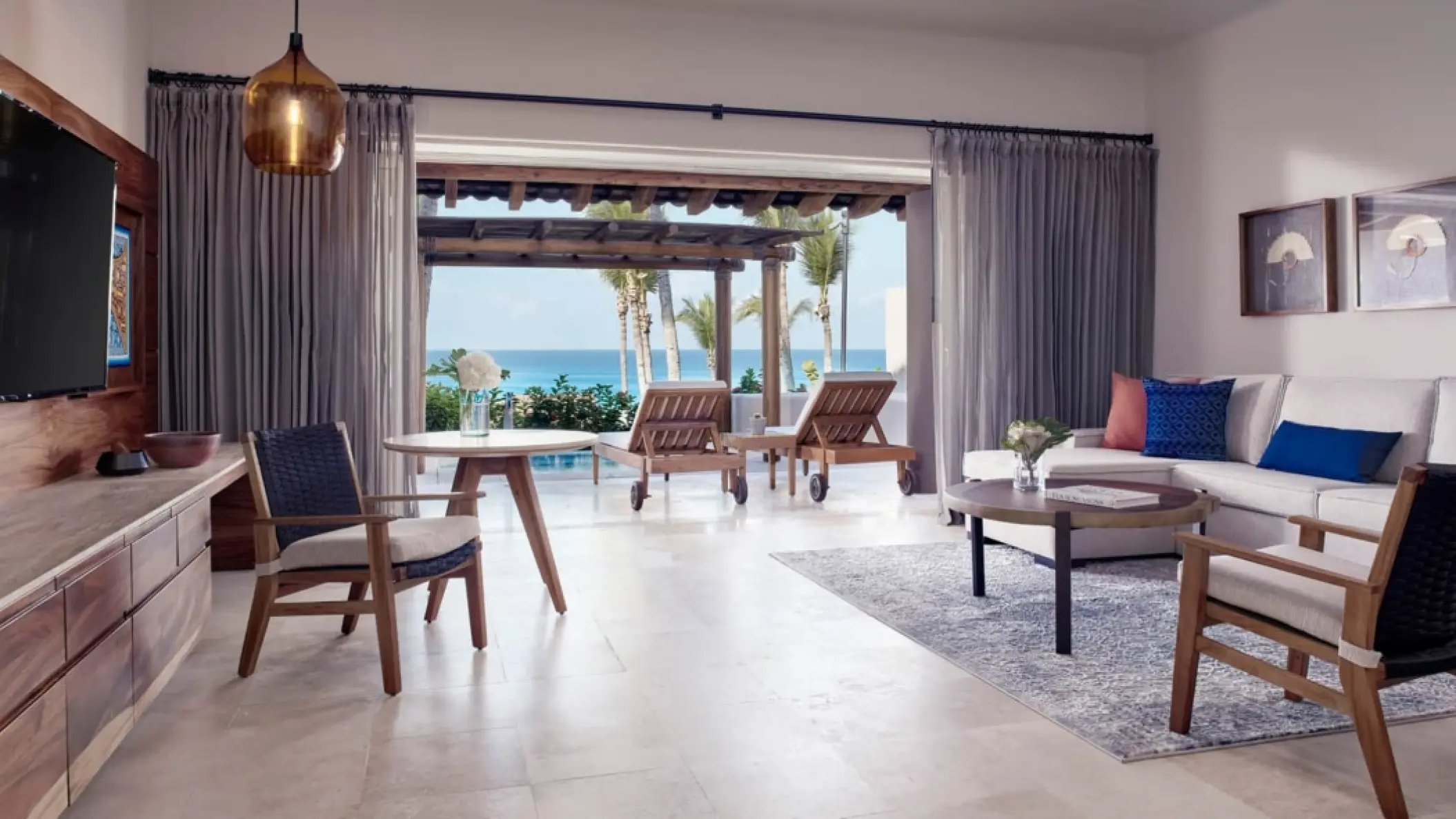 Modern suite living area opening to a terrace with ocean views at Four Seasons Punta Mita