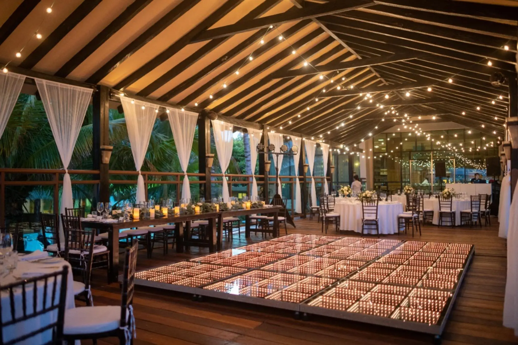 Pier deck wedding reception with an illuminated dance floor at Generations Riviera Maya