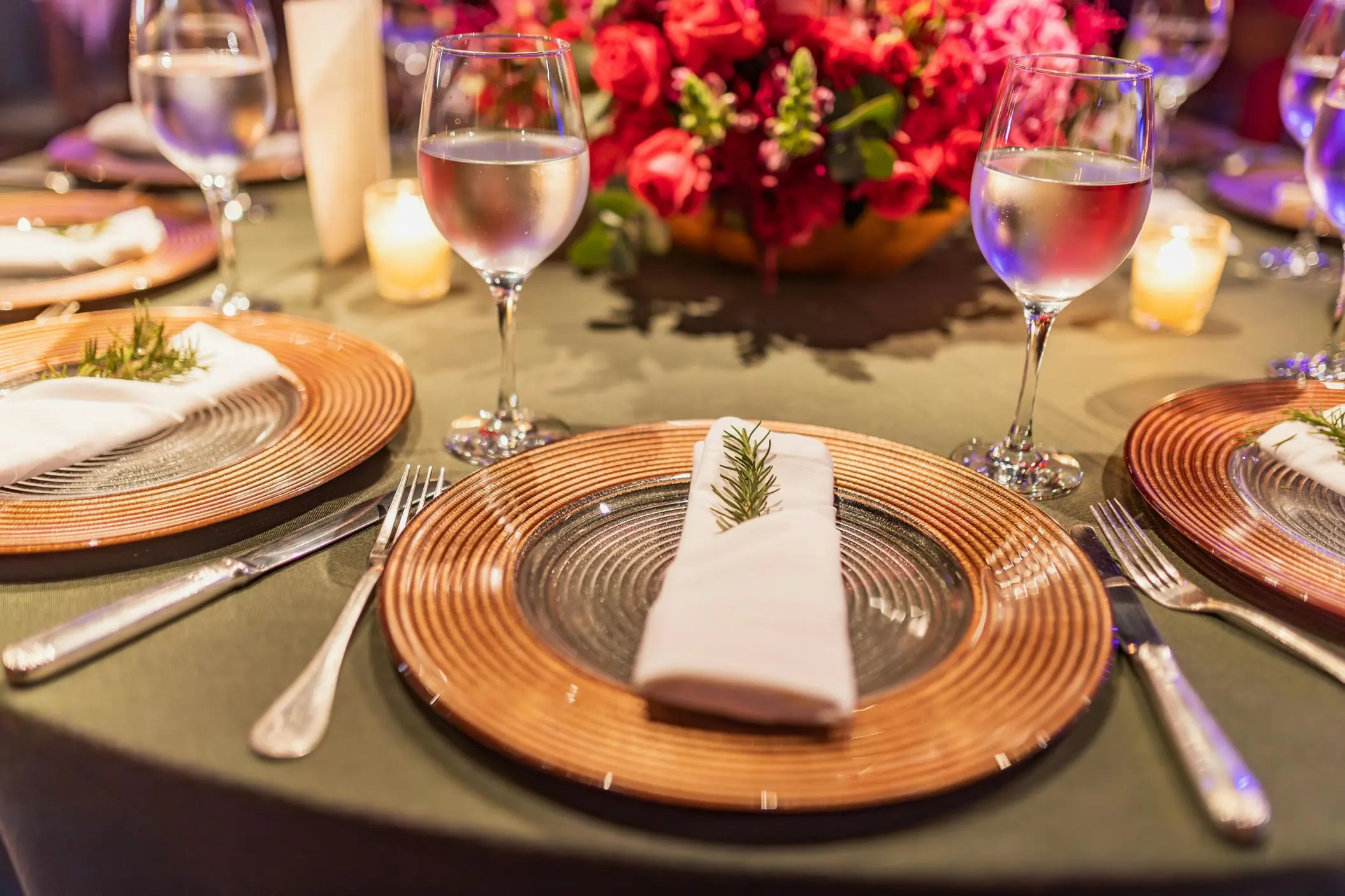 Wedding reception table setup with gold chargers and red floral centerpiece at Grand Bavaro Princess, Punta Cana