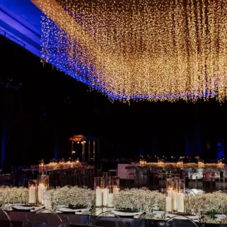 Grand ballroom wedding reception with hanging lights and floral centerpieces at Grand Fiesta Americana Coral Beach, Cancun