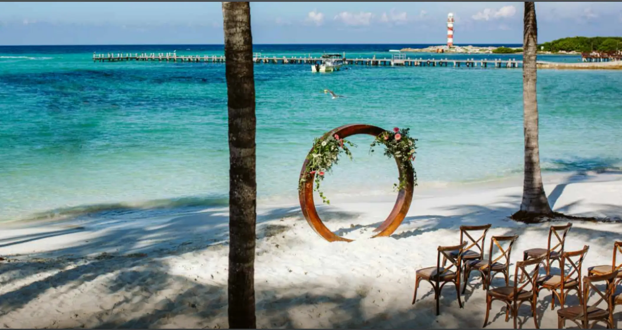 Sunrise Beach wedding ceremony with a circular arch at Grand Fiesta Americana Coral Beach, Cancun