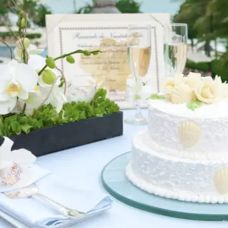 White tiered wedding cake with seashell decor at Grand Fiesta Americana Coral Beach, Cancun