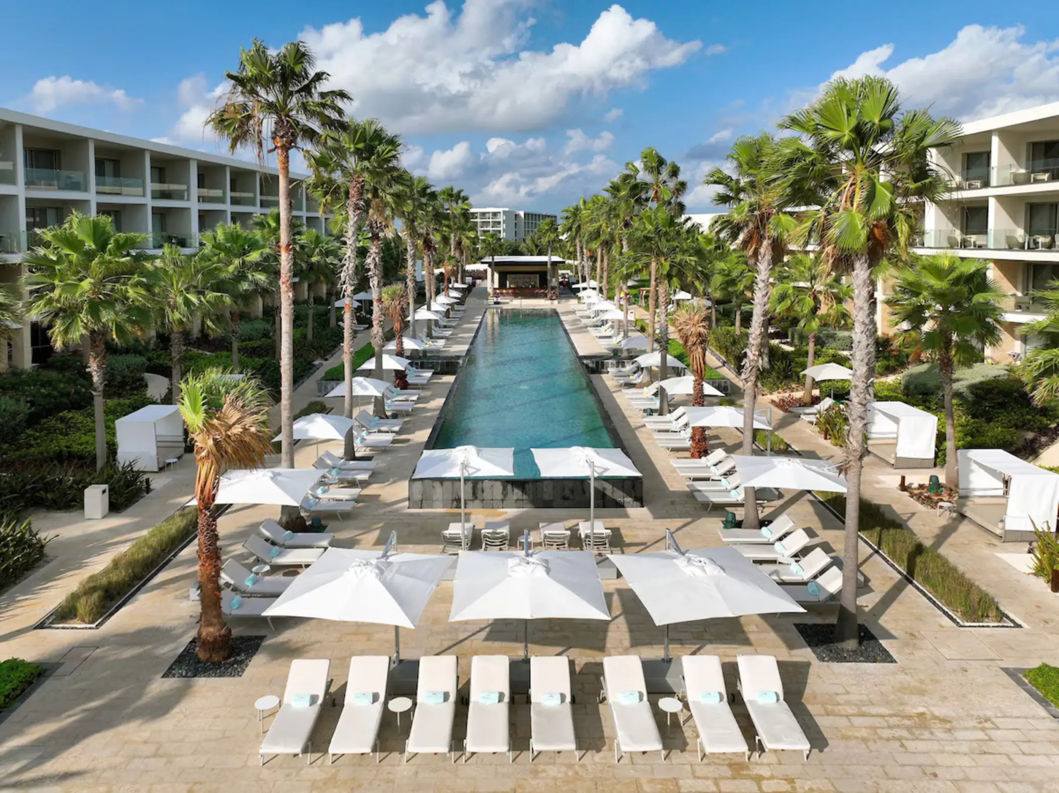 Long outdoor swimming pool and white cabanas at Grand Palladium Costa Mujeres, Cancun