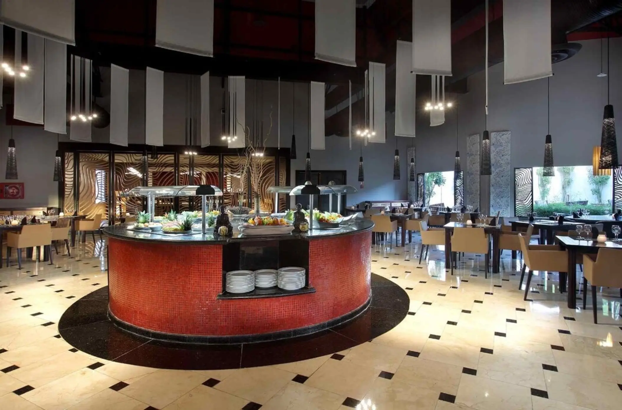 Buffet restaurant with circular serving station and hanging decor at Grand Palladium Punta Cana, Punta Cana