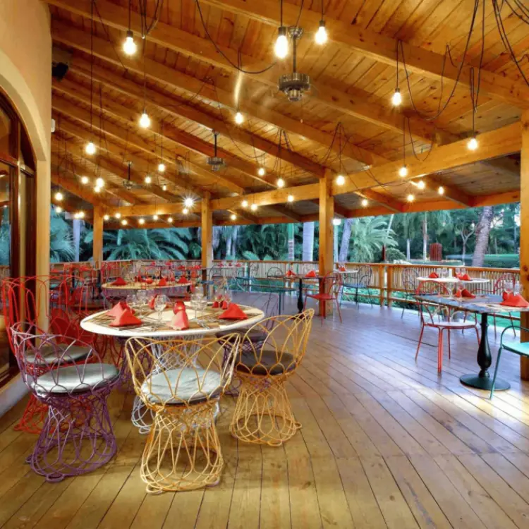 Poseidon restaurant with string lights and wooden beams at Grand Palladium Punta Cana