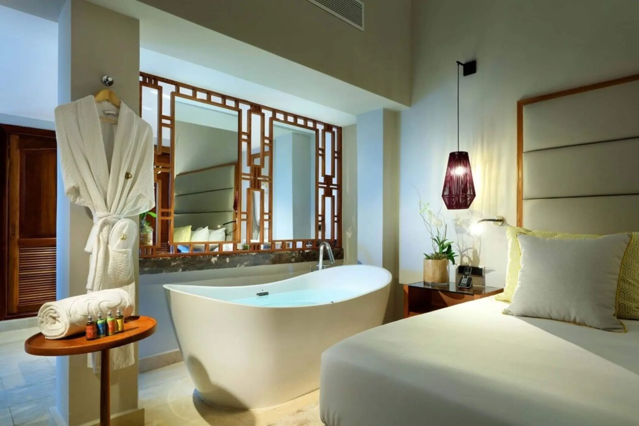 Modern guest suite with a freestanding bathtub and plush bedding at Grand Palladium Punta Cana