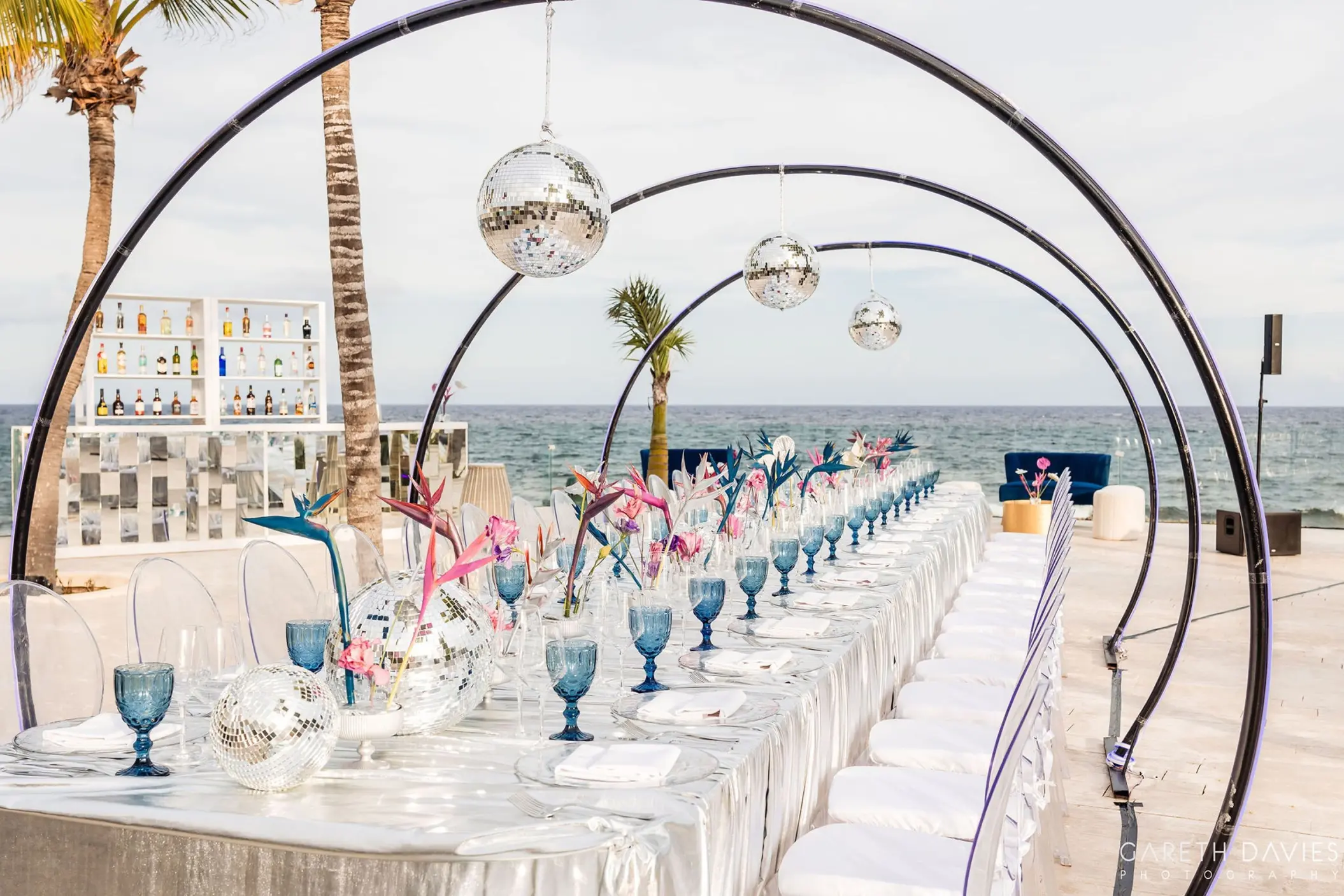 Long wedding reception table under disco ball arches at Grand Palladium Riviera Maya