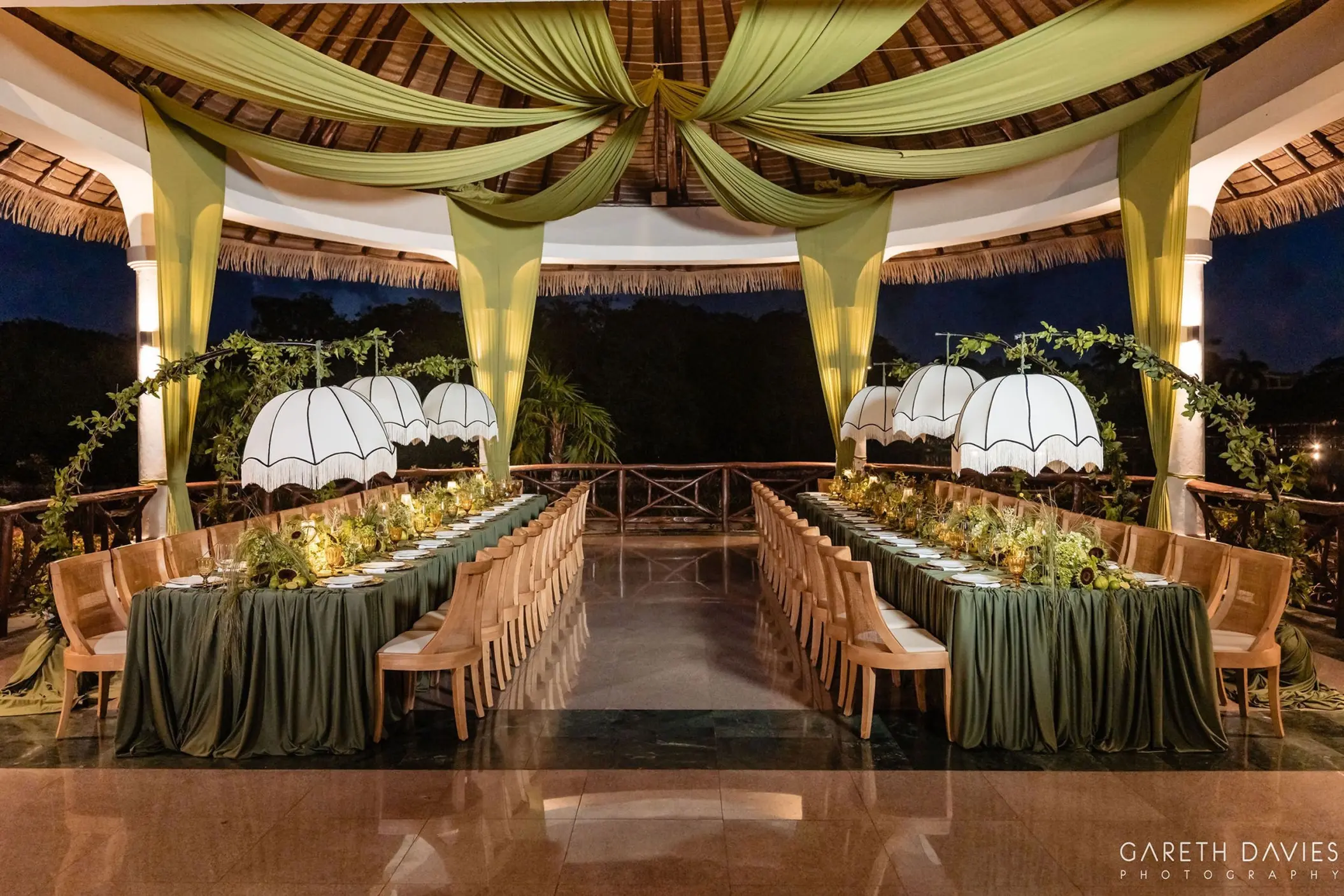 Terrace wedding reception with green drapes and white lanterns at Grand Palladium, Riviera Maya